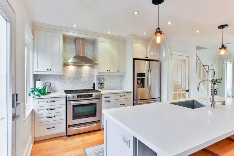 A bright and clean modern kitchen with white cabinets and counters